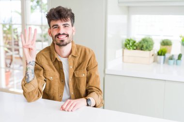 Gösterilen ve parmakları ile işaret beyaz masada oturan rahat ceket giyen genç adam ise kendinden emin ve mutlu gülümseyerek dört numara.