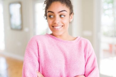 Afro saçlı görünümlü yan ve dik dik bakma uzağa düşünce gülümseyen güzel genç Afro-Amerikan kadın.