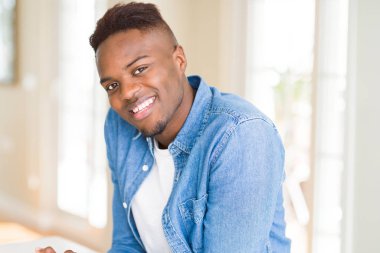 Gülümseyen yüzünde kocaman bir gülümseme ile neşeli Afrika yakışıklı genç