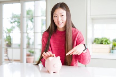 Yazı tura domuz çanta içinde çok mutlu el ve parmak ile işaret koyarak güzel Asyalı kadın