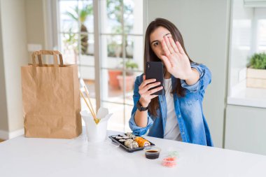 Güzel genç kadın gıda teslim açık eliyle dur işareti ile ciddi ve kendine güvenen ifade, savunma jest yapıyor smartphone kullanarak app üzerinden sipariş