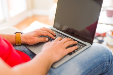 Evde kanepede otururken dizüstü kullanan orta yaş adam