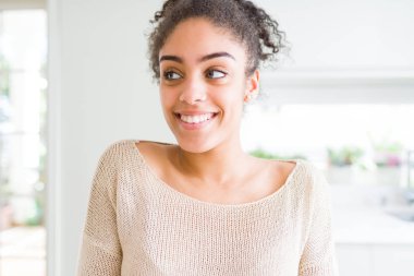 Afro saçlı görünümlü yan ve dik dik bakma uzağa düşünce gülümseyen güzel genç Afro-Amerikan kadın.