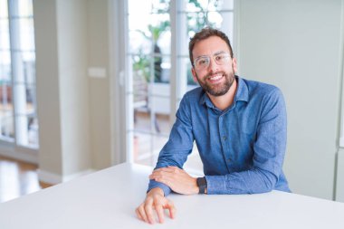 Gözlük takan ve gülümseyen yakışıklı adam kameraya rahat