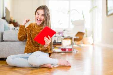 Gurur çığlık ve zafer ve başarı çok heyecanlı, kutluyor katta oturan dijital dokunmatik tablet kullanarak güzel genç kız çocuk duygu tezahürat
