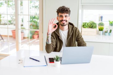 Bilgisayar laptop ve defter parmak, mükemmel sembolü ile ok işareti yapıyor kullanan genç öğrenci adam