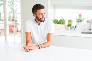 Yakışıklı İspanyol casual beyaz t-shirt ev uzak tarafına gülümseme ile yüzünde, doğal ifade arıyorum, dostum. Kendine güvenen gülüyor.
