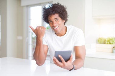 Afrika kökenli Amerikalı adam işaret ve başparmak kadar mutlu yüz gülümseyen tarafı ile gösterilen touchpad tablo kullanma