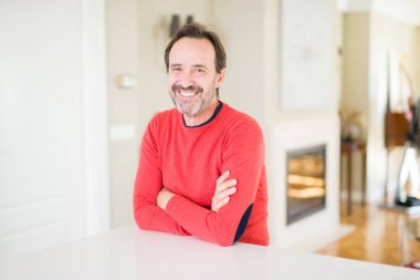 Evde kameraya bakarak gülümseyen yakışıklı orta yaş erkek