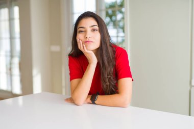 Beyaz masa düşünme görünümlü genç güzel kadın evde yorgun ve sıkılmış çapraz silah depresyon sorunları ile.