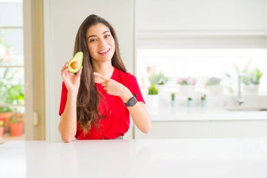 Genç kadın sağlıklı avokado çok mutlu el ve parmak ile işaret yeme