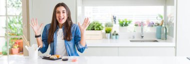 Güzel genç kadın deli ve çığlık kaldırdı ve açık gözleri heyecanlı silah ile başarı için hayran suşi teslim kutluyor yeme geniş açı resim. Kazanan kavramı