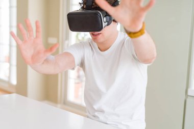 Genç adam eğleniyor evde sanal gerçeklik gözlüklü