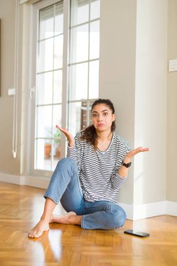 Ev clueless ve şaşkın bir ifadeyle kollar ve eller kaldırdı katta oturan genç güzel kadın. Şüphe kavramı.