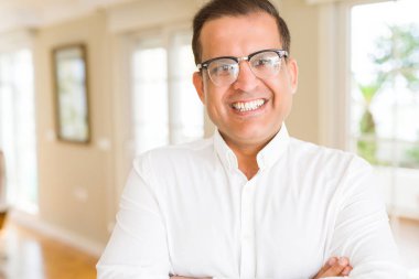 Evde kameraya gülümseyen gözlük takan orta yaş erkek