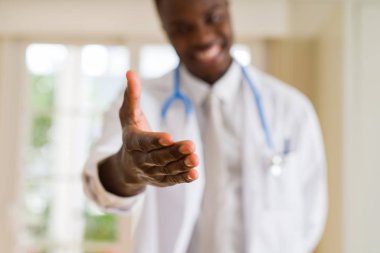 Bir Afrikalı doktor el hoş geldiniz el sallamak ve gülümseyen sunan yakın çekim