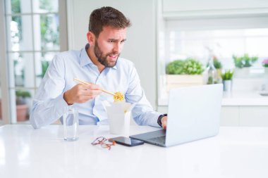 İş adam yeme Asya erişte yemek sırasında çalışma u götürün