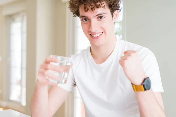 Jeune Homme Buvant Verre Eau Maison Criant Fier Célébrant Victoire — Photo