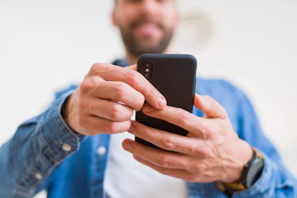 Detailní záběr z rukou člověka pomocí smartphone a usmívá se — Stock fotografie