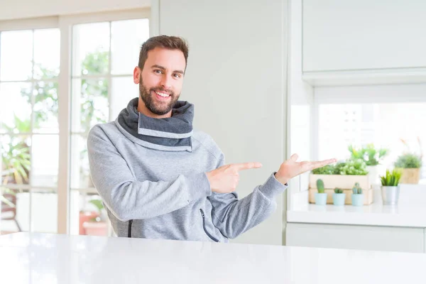 Hombre Guapo Casa Sorprendido Sonriendo Cámara Mientras Presenta Con Mano — Foto de Stock