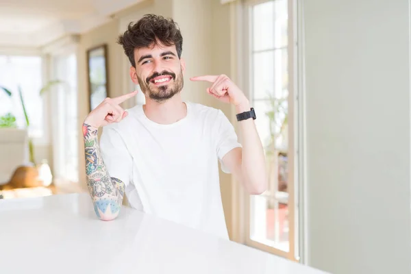 Hombre Joven Con Camiseta Casual Sentado Mesa Blanca Sonriendo Confiado — Foto de Stock