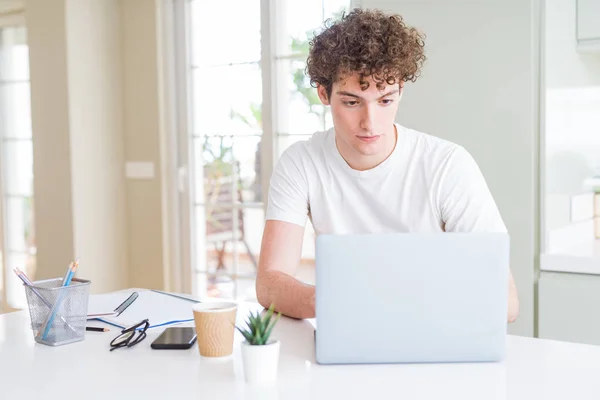 若い学生男考えて深刻なスマートの顔に自信を持って表現でラップトップ コンピューターを使用すること — ストック写真