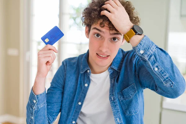 Joven Sosteniendo Tarjeta Crédito Estresado Con Mano Cabeza Sorprendido Con —  Fotos de Stock