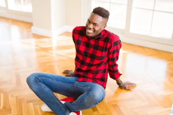 英俊的非洲年轻人微笑着自信地坐在地板上 面带微笑 — 图库照片