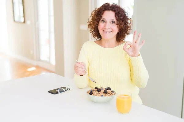 Mujer Mayor Comiendo Desayuno Saludable Por Mañana Casa Haciendo Signo —  Fotos de Stock