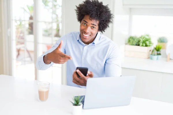 スマート フォンとノート パソコンの手と指で指している非常に幸せを使用してアフリカ系アメリカ人ビジネスマン — ストック写真