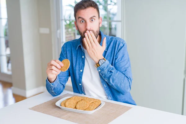 Stilig Man Äta Hälsosamt Fullkorn Kex Täcka Munnen Med Handen — Stockfoto