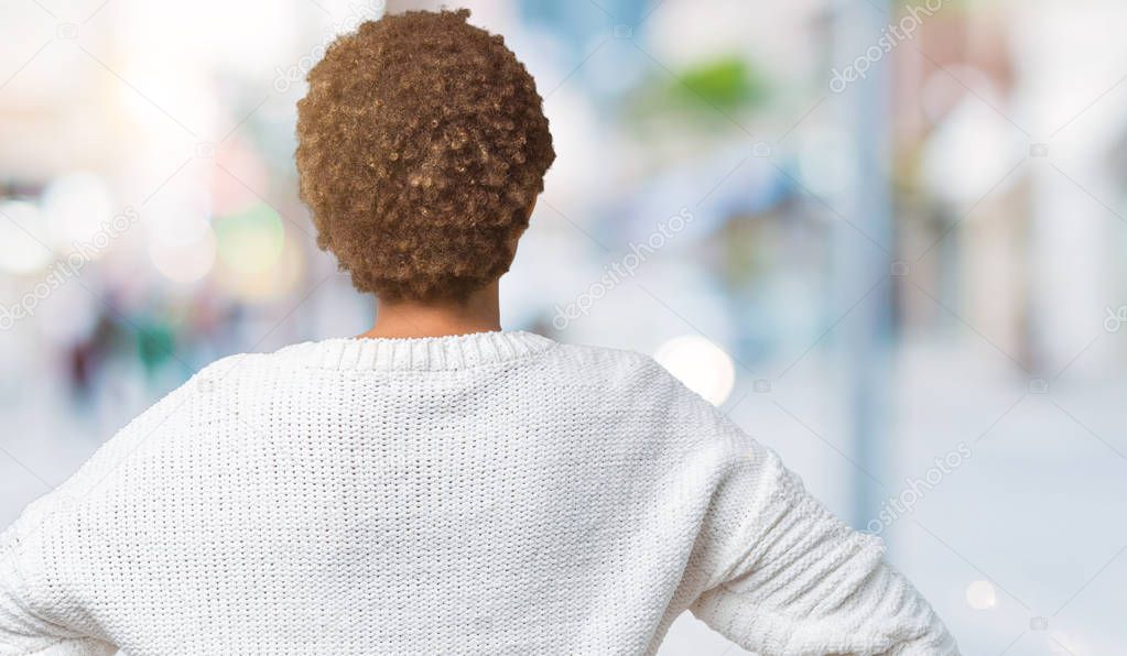 Beautiful young african american woman wearing sweater over isolated background standing backwards looking away with arms on body