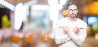 Genç yakışıklı adam gözlük izole üzerinde işaretleme için her iki parmak, farklı yönde ile katılmıyorum arka plan