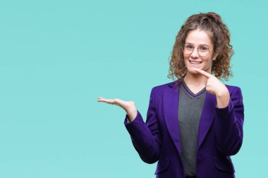 Okul üniforması ve gözlük hayrete ve el ile sunulması ve parmak ile işaret ederken kameraya gülümseyen izole arka plan üzerinde giyen genç esmer öğrenci kız.