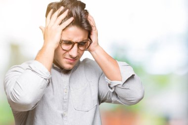 Çünkü çaresiz ve stresli baş ağrısı acı izole arka plan üzerinde gözlüklü genç yakışıklı adam ağrı ve migren. Ellerini kafasına.