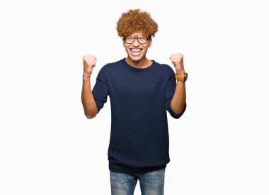 Afro kutluyor gözlük takan genç yakışıklı adamla şaşırttı ve başarı için kaldırdı kollarını açarak hayret ve gözleri açık. Kazanan kavramı.