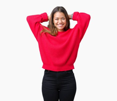 Arka plan üzerinde kırmızı kış kazak giyen genç güzel esmer kadın izole rahatlatıcı ve kollar ve eller baş ve boyun, mutlu gülümseyerek arkasında ile germe