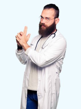 Genç sarışın doktor adam sakal giyen ile tıbbi kat el hareketi ile sembolik silah tutan çekim silah, kızgın yüz öldürmek oynamaya