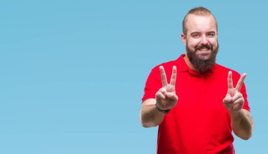 Zafer işareti yapıyor parmak gösterilen kamera seyir gülümseyen izole arka plan üzerinde kırmızı gömlek giymiş genç beyaz hipster adam. İki numaralı.