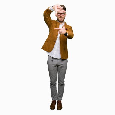 Elle yapma çerçeve ve parmakları ile mutlu yüz gülümseyen gözlüklü genç yakışıklı iş adamı. Yaratıcılık ve Fotoğrafçılık kavramı.