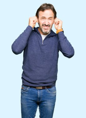 Orta yaş yakışıklı adamın gülen çekerek bir kazak giydiğini parmaklarıyla, komik jest kulaklar. Seçmelere sorun