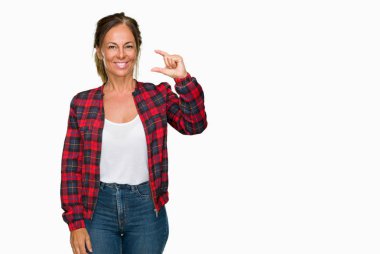 İzole arka plan gülümseyen ve boyutu işaret parmaklı ararken ve kamera işi el ile kendinden emin eller üzerinde rahat ceket giyen orta yaş yetişkin kadın. Ölçü kavramı.