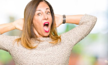 Moda kazak deli giyen ve baş, korkuyor ve açık ağzı ile şok sürpriz elleriyle korkuttu güzel orta yaş kadın