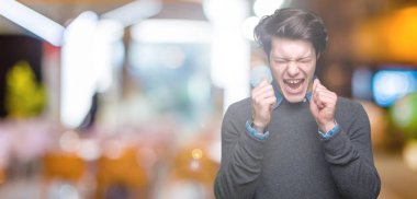 Genç yakışıklı zarif adam izole arka kolları olan başarı için heyecan üzerinde zafer kutluyor gülümseyen kaldırdı. Kazanan kavramı.