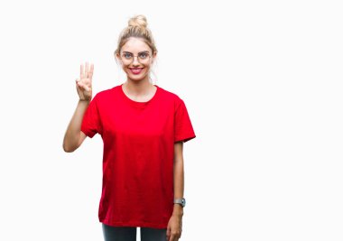 Gösterilen ve parmakları ile işaret izole arka plan üzerinde kırmızı t-shirt ve gözlük giyen genç güzel sarışın kadın kendinden emin ve mutlu gülümseyerek iken üçüncü.