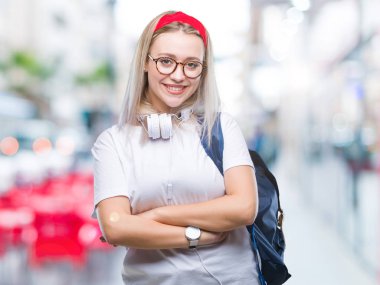 Gözlük ve sırt çantası üzerinde giyen genç sarışın öğrenci kadın mutlu yüz ile gülümseyerek kameraya seyir silah geçti arka plan izole. Olumlu bir kişi.