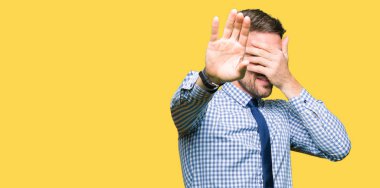 Yakışıklı iş adamı giyen kapsayan gözleri elleri ile kravat ve stop jest ile acı ve korku ifadesi. Utandım ve negatif kavramı.