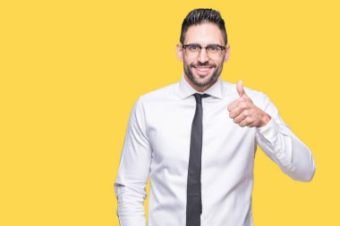 Hareketi el ile mutlu yaşasın yapıyor izole arka plan üzerinde gözlük takan genç yakışıklı iş adamı. Başarı gösteren kameraya bakarak ifade onaylama.