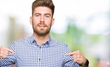 Yüzünde gülümseme ile kendinden emin görünüyorsun, kendini gururlu ve mutlu parmakları ile işaret genç yakışıklı bussines adam.