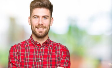 Genç yakışıklı mutlu yüz çapraz kollu kameraya bakarak gülen adam. Olumlu bir kişi.